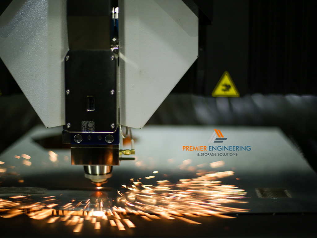 Industrial fibre laser cutting machine processing sheet steel in a metal fabrication workshop.