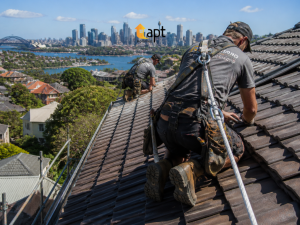 Roofing contractors using appropriate fall protection while working on a steep residential roof in Sydney